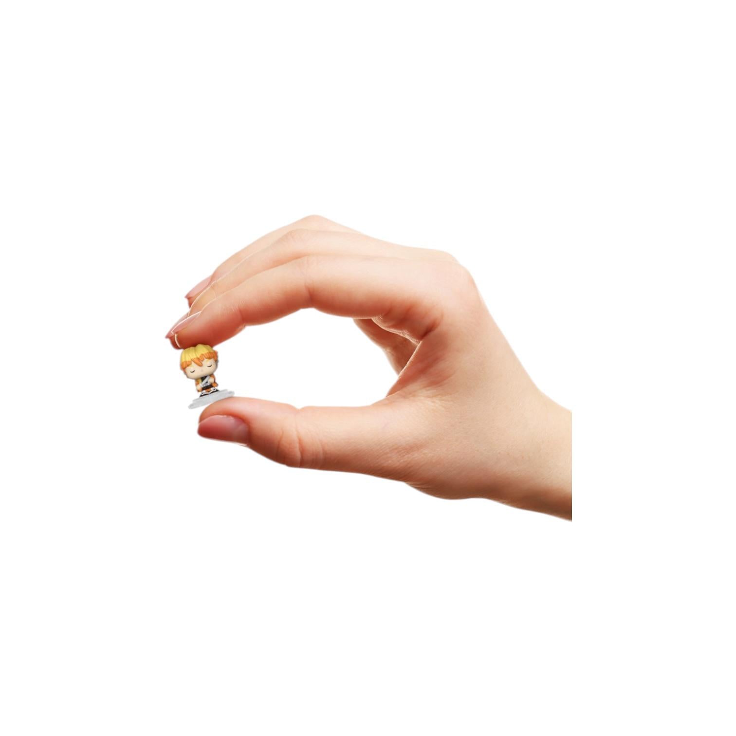 Hand holding a small figurine against a white background