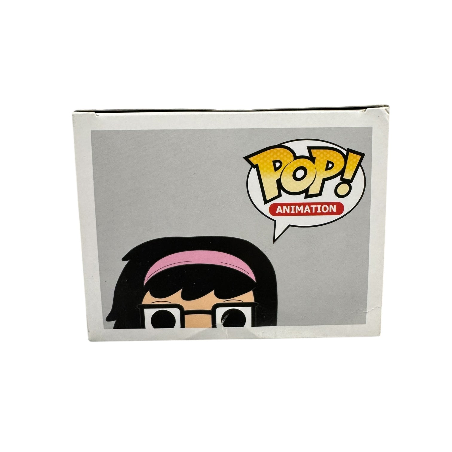 Tina Belcher dressed in pink work out attire and a pink sweatband. Black framed glasses with hands on her hips. Top of box. Slight damage to the top of the box.