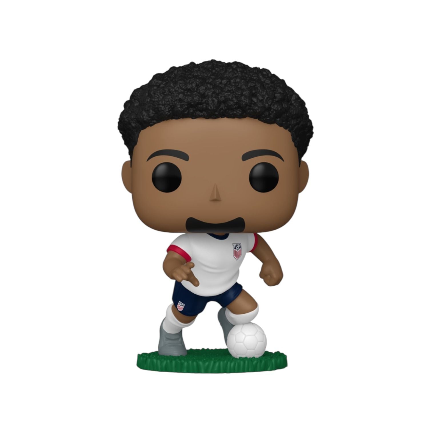 Figurine of a soccer player in a white jersey with a ball on a grass patch, on a white background