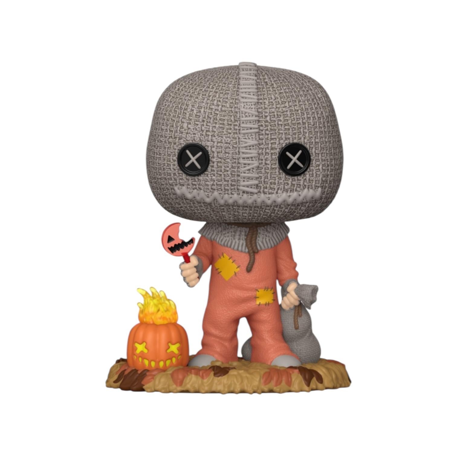 Figurine of a character with a knitted cap and orange overalls holding a pumpkin lantern on a white background