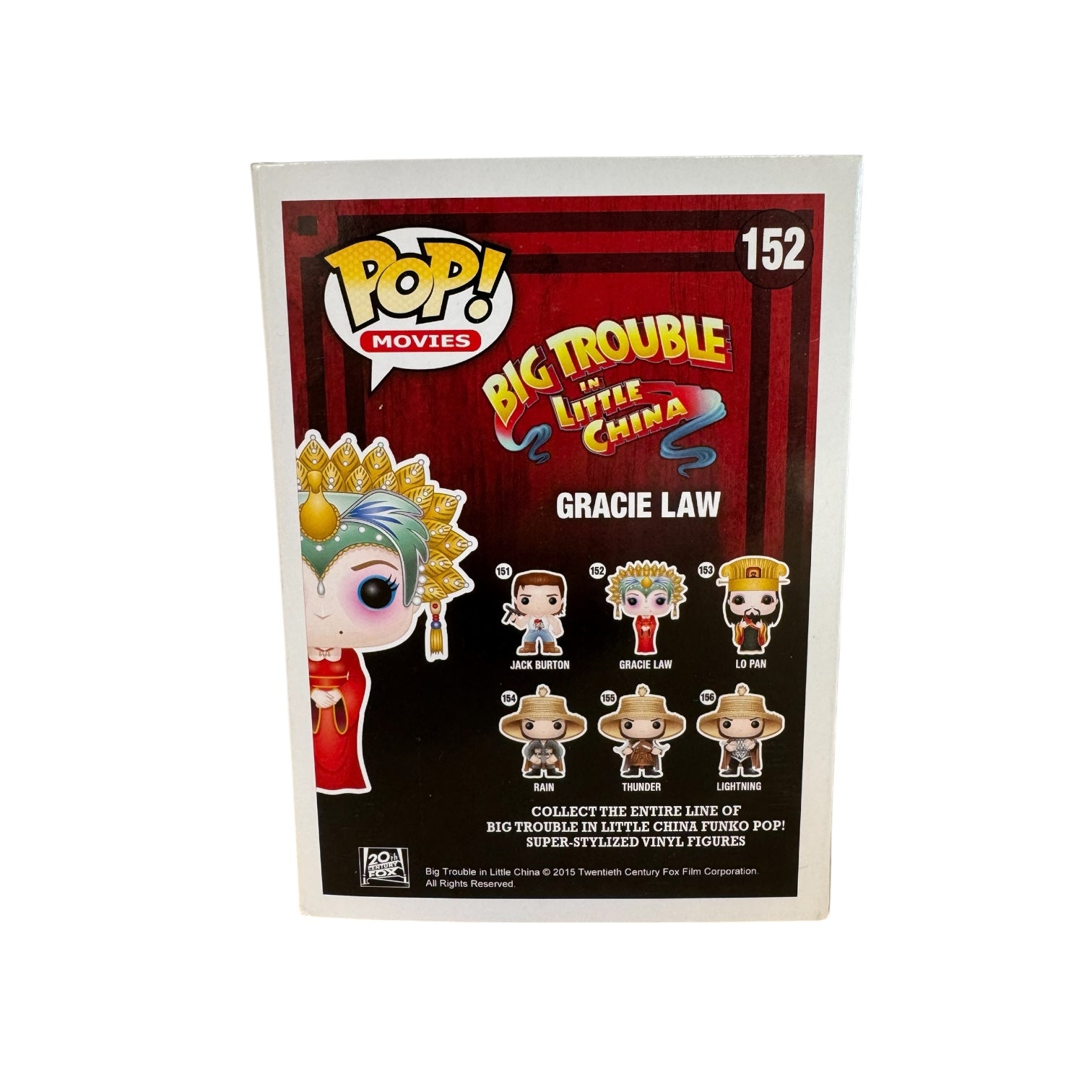 Woman wearing red dress, green and hold head piece and blue and pink eye make up. 