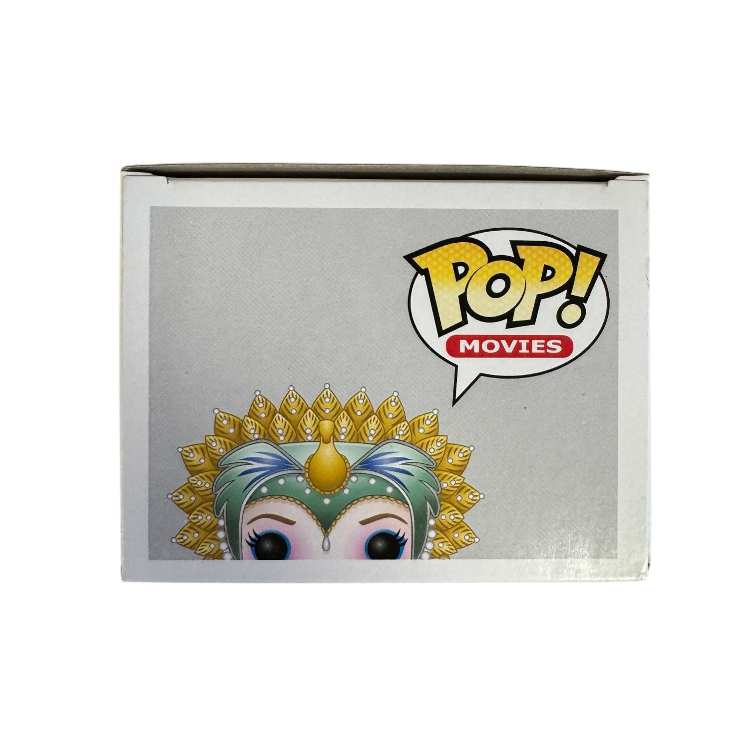 Woman wearing red dress, green and hold head piece and blue and pink eye make up. 