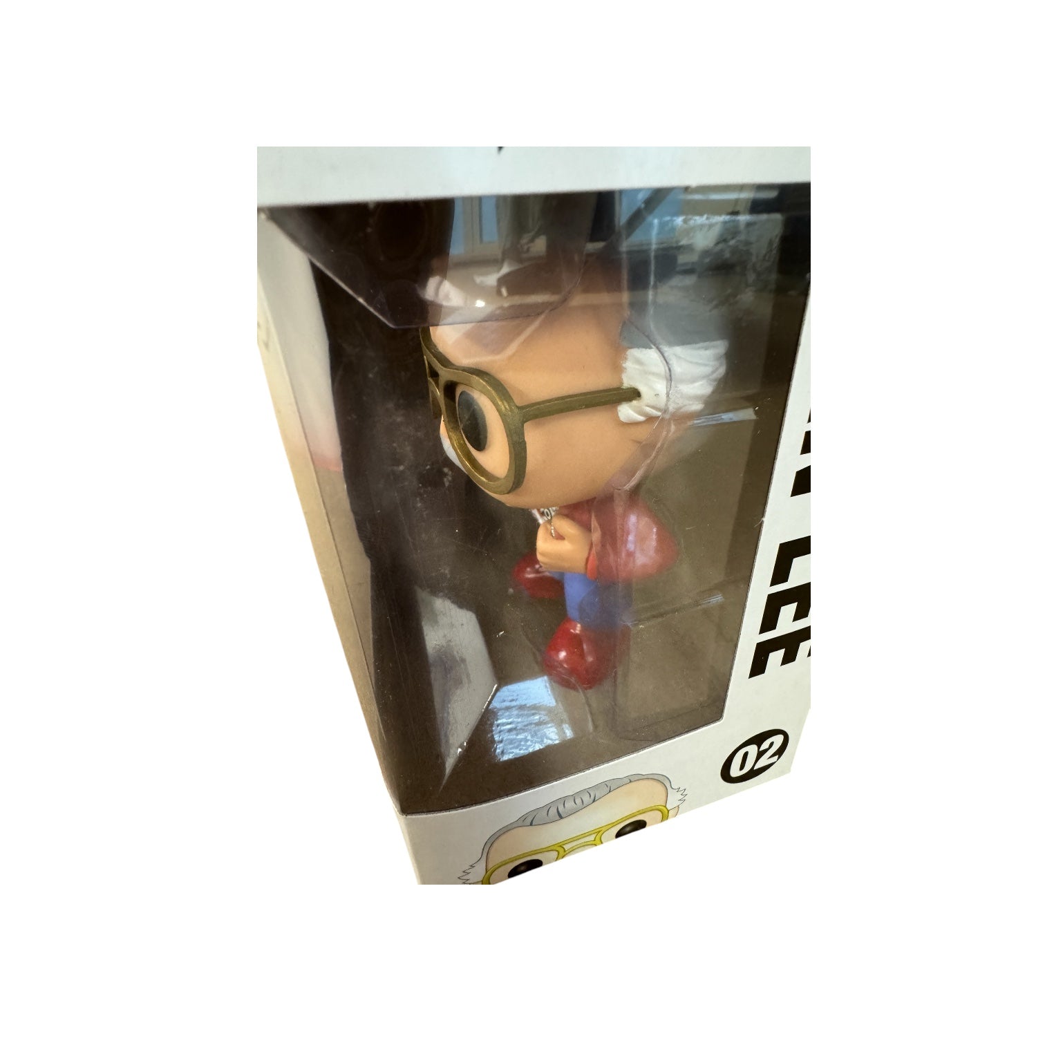 Stan Lee standing with his hands pulling apart a red jumper showing a white t-shirt that says 'Fan Expo' wearing red boots.