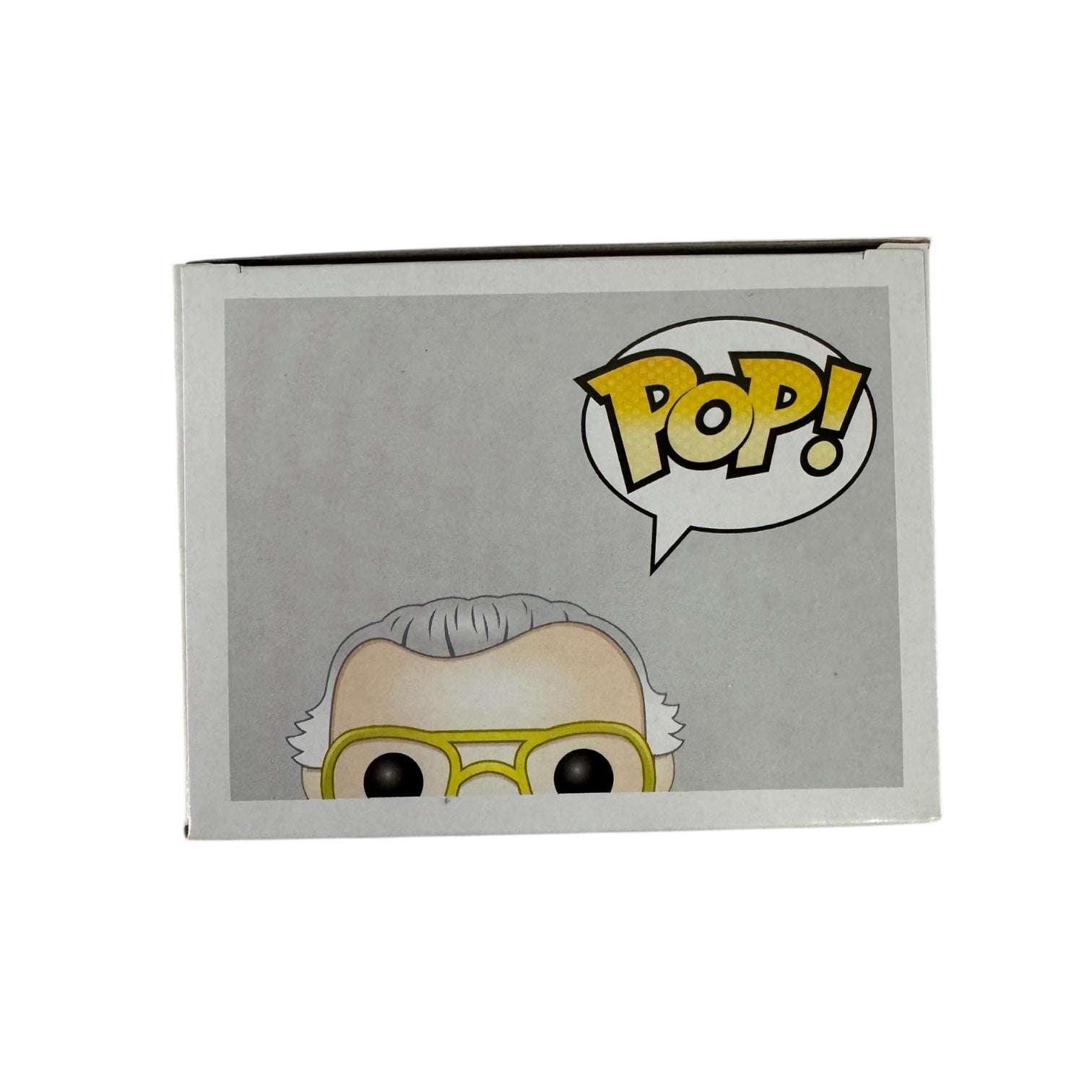 Stan Lee standing with his hands pulling apart a red jumper showing a white t-shirt that says 'Fan Expo' wearing red boots.